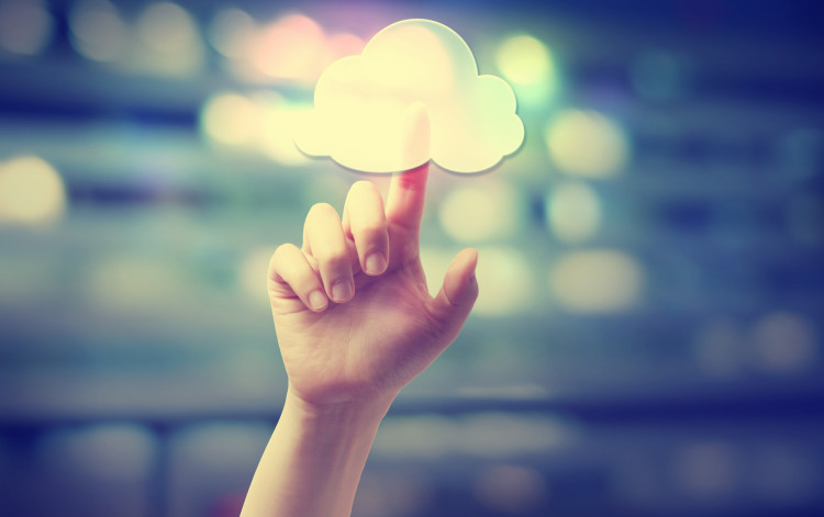 Hand pressing a cloud computing icon on blurred cityscape background